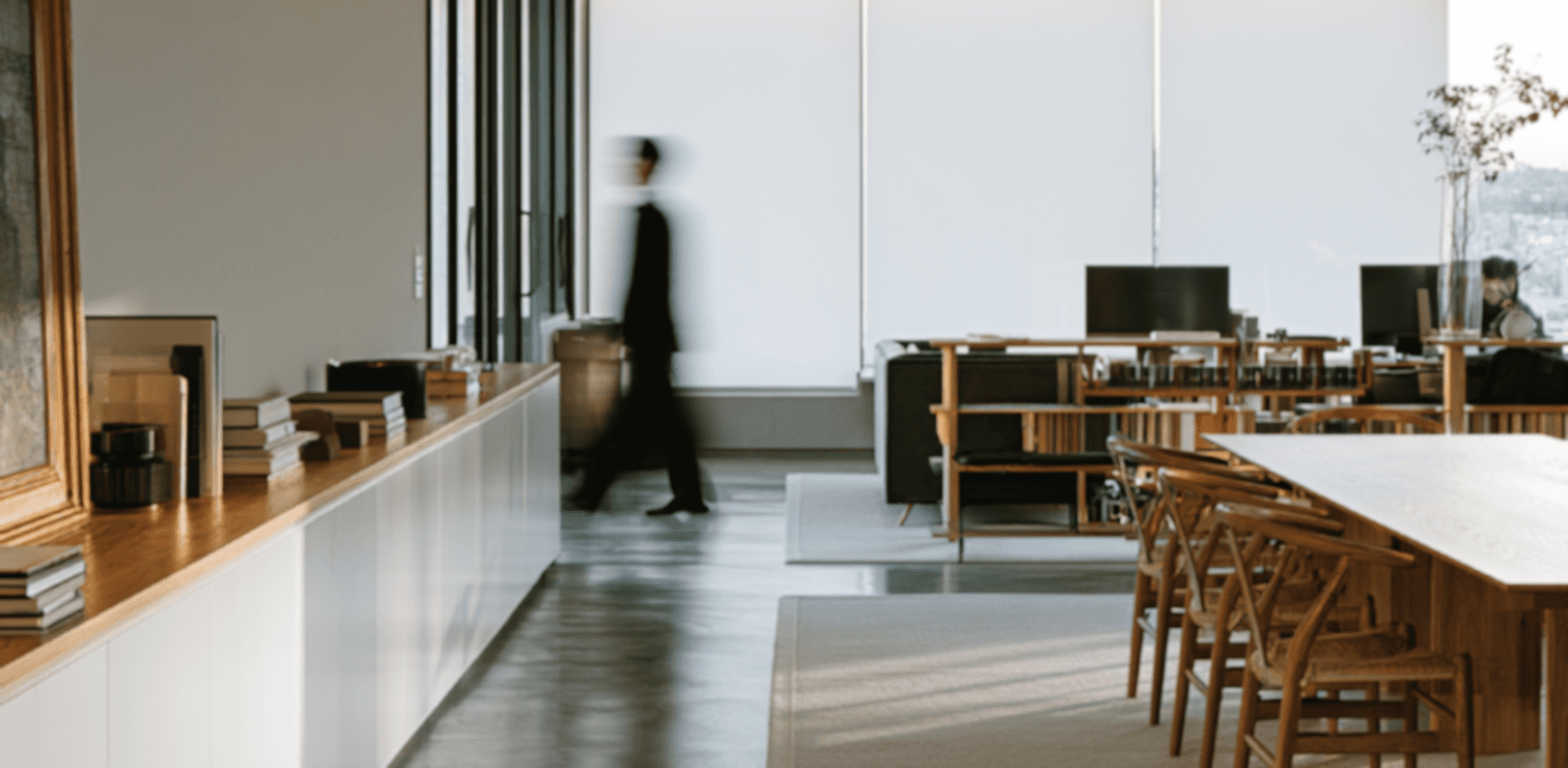 Open-plan office with a person walking past the desks